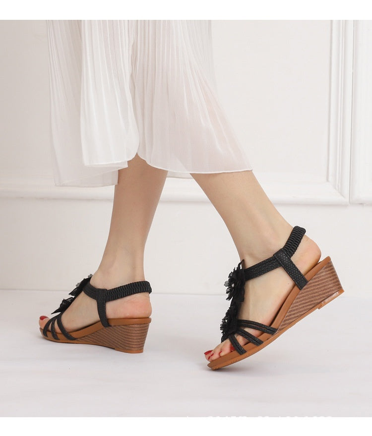 Kenike wedge Roman Bohemian retro flower vacation sandals with floral design and comfortable straps on a sandy background.